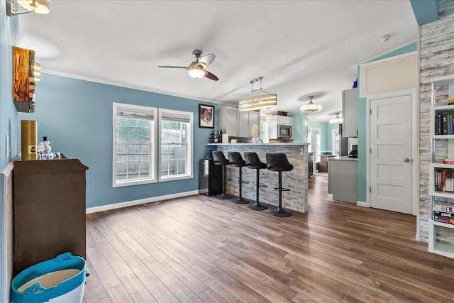 11372 Powhatan Path, Lakeview, OH 43331 - living area featuring ceiling fan, dark wood-style flooring, crown molding, and a textured ceiling