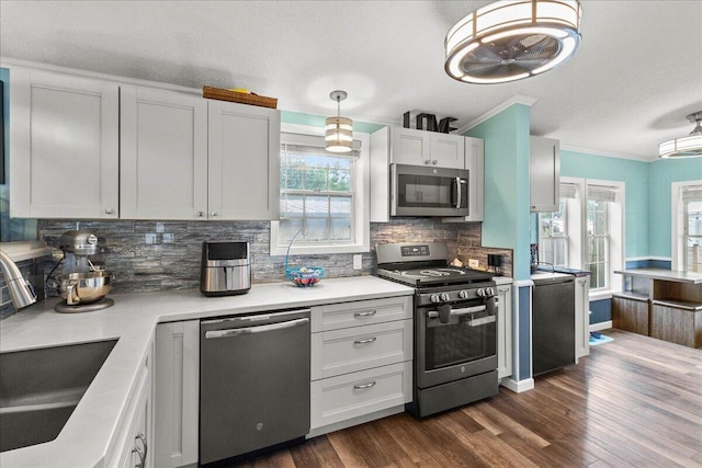 11372 Powhatan Path, Lakeview, OH 43331 - kitchen featuring stainless steel appliances, ornamental molding, decorative backsplash, dark wood-style flooring, and light countertops