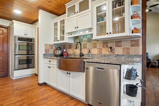 891 N Tecumseh Rd, Springfield, OH 45504 - kitchen with appliances with stainless steel finishes, wood ceiling, backsplash, wood finished floors, and white cabinets