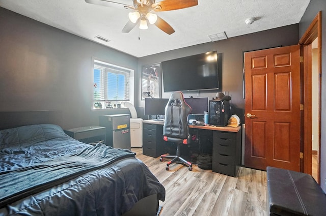 891 N Tecumseh Rd, Springfield, OH 45504 - bedroom with light wood-style floors, a ceiling fan, a textured ceiling, and an office area