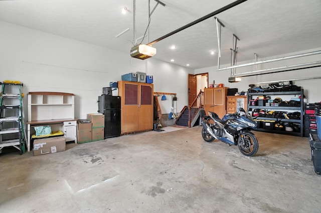 891 N Tecumseh Rd, Springfield, OH 45504 - garage featuring freestanding refrigerator, a garage door opener, and recessed lighting