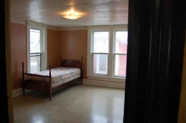 bedroom featuring baseboards and light floors