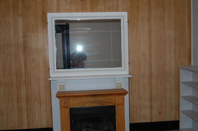 room details featuring wooden walls and a fireplace