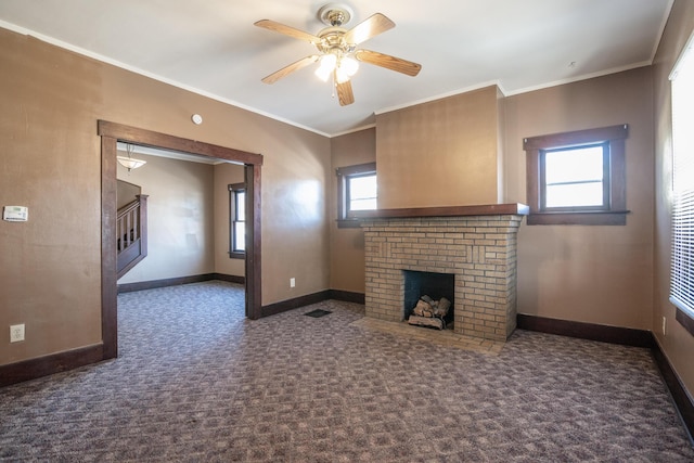 unfurnished living room featuring crown molding, plenty of natural light, and a fireplace