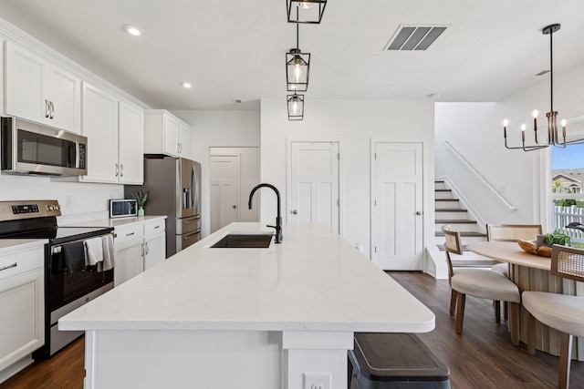 8202 Cherry Birch Dr, Tipp City, OH 45371 - kitchen with appliances with stainless steel finishes, dark wood finished floors, a center island with sink, white cabinetry, and recessed lighting