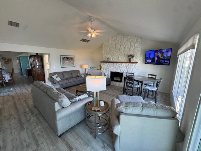 14072 Seminole Path, Lakeview, OH 43331 - living area featuring wood finished floors, lofted ceiling, healthy amount of natural light, a ceiling fan, and a fireplace