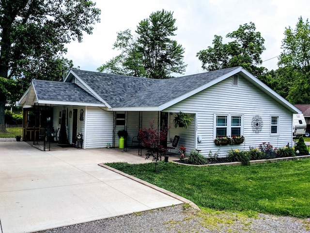 ranch-style house featuring a porch, a shingled roof, driveway, and a front yard