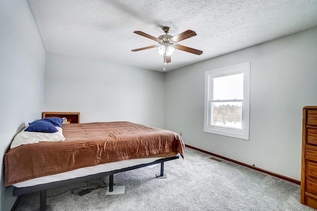 bedroom with a textured ceiling, carpet floors, and baseboards