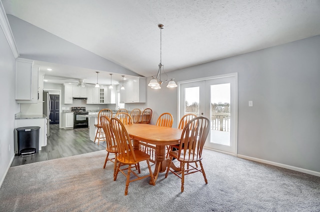 dining area featuring lofted ceiling, baseboards, a textured ceiling, and french doors