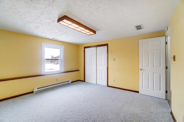 unfurnished bedroom with carpet, a baseboard radiator, a closet, visible vents, and baseboards