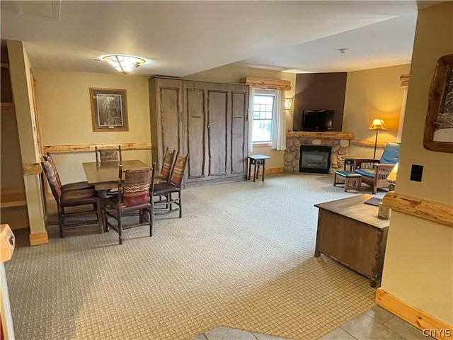 living area featuring a stone fireplace and light carpet