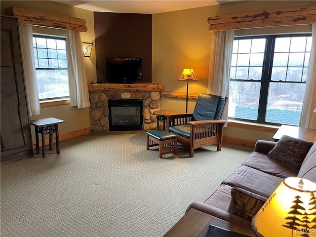 carpeted living room with a stone fireplace