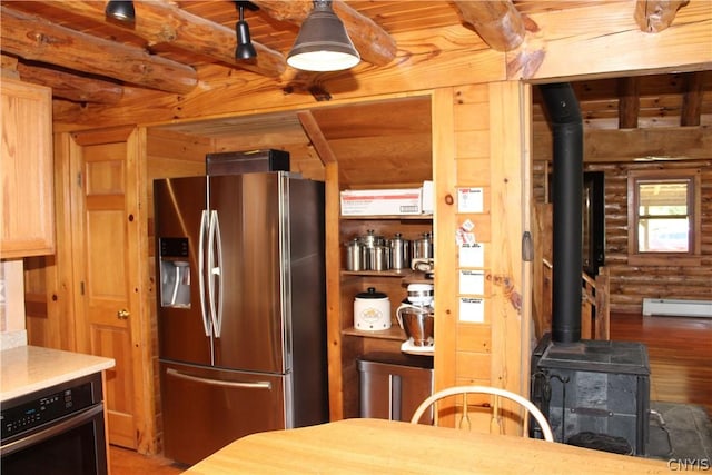 kitchen with log walls, stainless steel fridge, a wood stove, dark hardwood / wood-style floors, and black oven