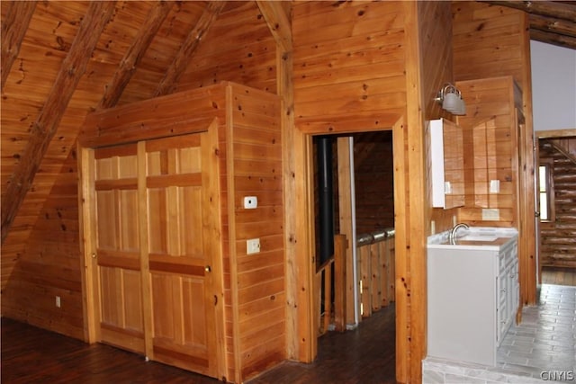 kitchen with wooden walls, wood ceiling, white cabinetry, and dark hardwood / wood-style flooring