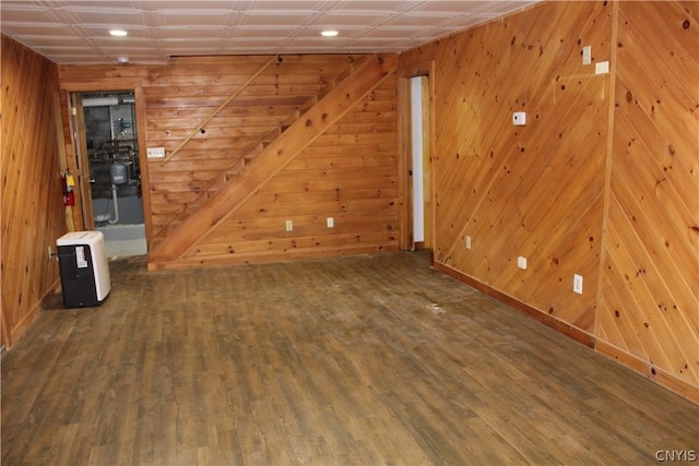 spare room featuring wooden walls and dark hardwood / wood-style flooring