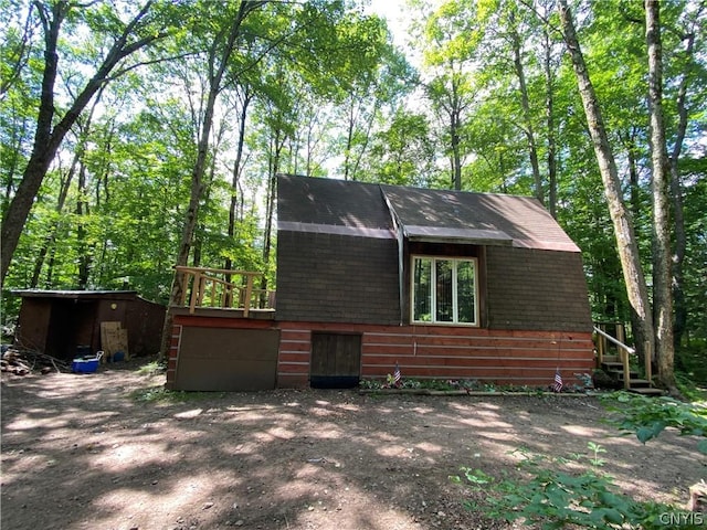 view of side of home featuring a shed