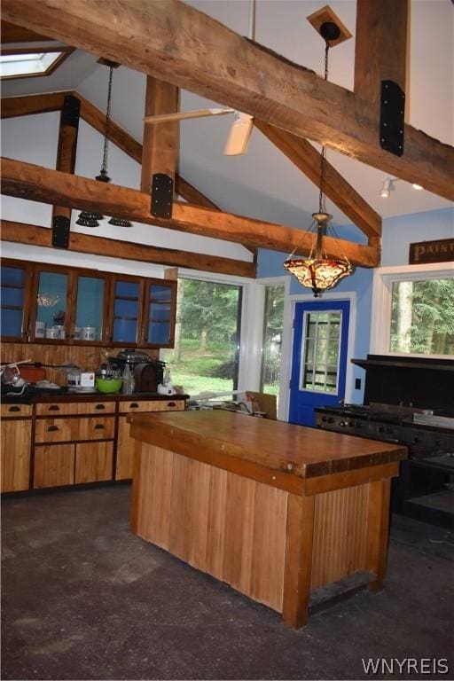 kitchen with beamed ceiling, a kitchen island, wood counters, high vaulted ceiling, and hanging light fixtures