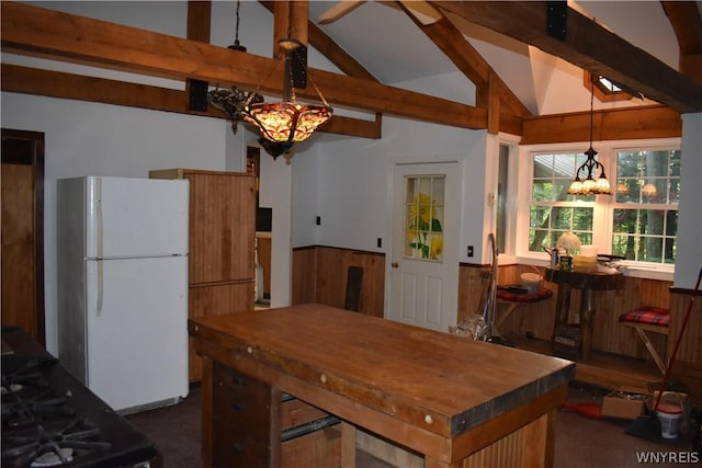 kitchen with a notable chandelier, white fridge, decorative light fixtures, dark carpet, and lofted ceiling with beams