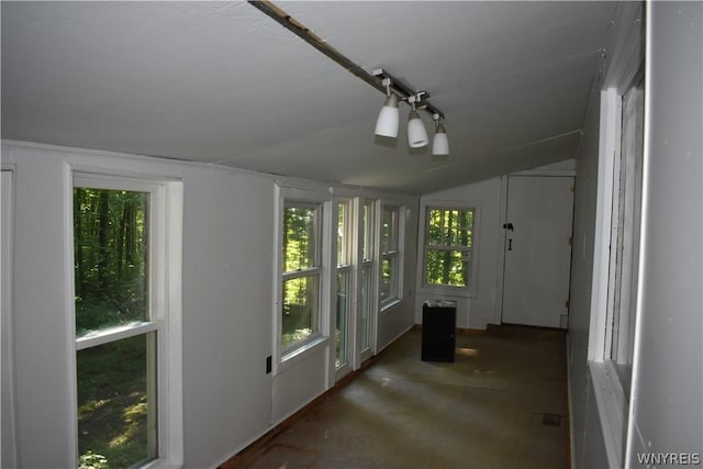 unfurnished sunroom featuring lofted ceiling and a healthy amount of sunlight