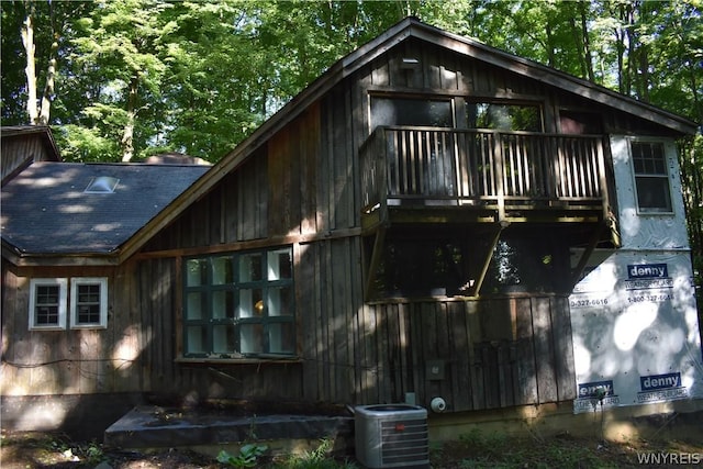 view of front of home featuring a balcony and central AC