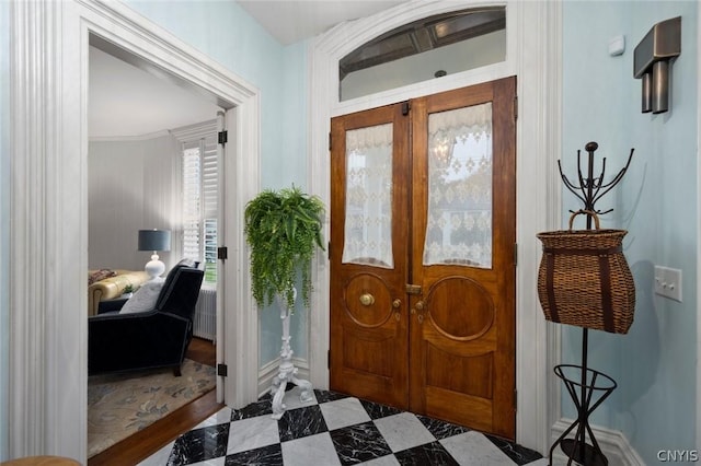 tiled entrance foyer featuring ornamental molding