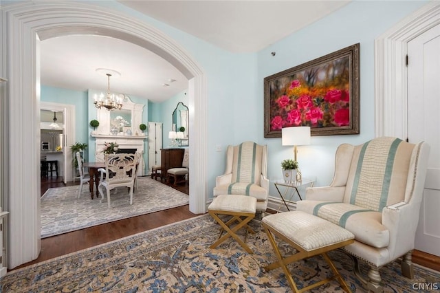 sitting room with a notable chandelier and dark hardwood / wood-style flooring