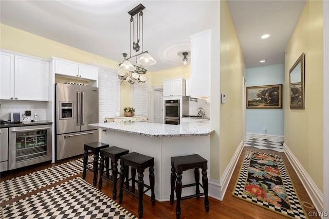 kitchen with backsplash, beverage cooler, dark wood-type flooring, and appliances with stainless steel finishes