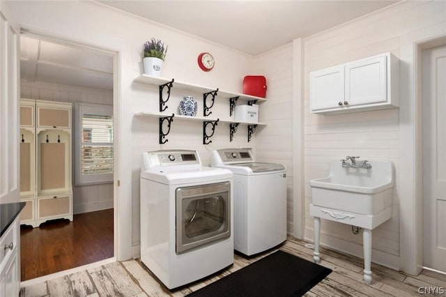 washroom featuring washing machine and dryer, crown molding, and light wood-type flooring