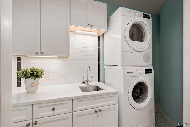 washroom with cabinets, tile flooring, stacked washer and clothes dryer, and sink