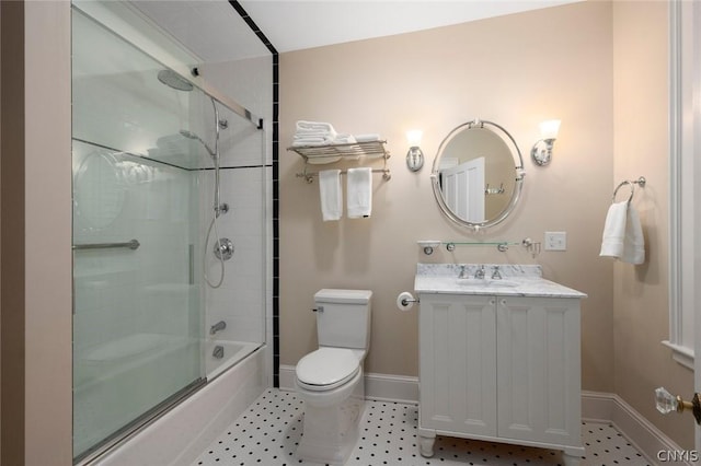 full bathroom with tile flooring, enclosed tub / shower combo, toilet, and vanity