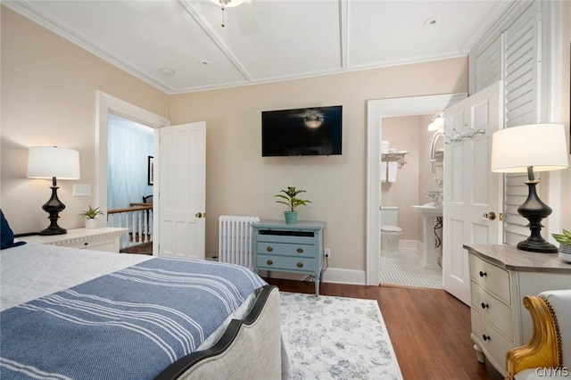 bedroom featuring ceiling fan, dark wood-type flooring, ensuite bath, and radiator heating unit