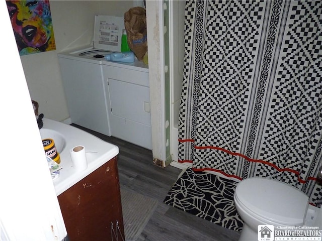 bathroom with toilet, vanity, independent washer and dryer, and hardwood / wood-style flooring