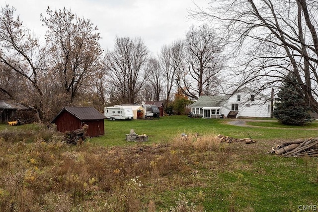 view of yard with a storage unit and a fire pit