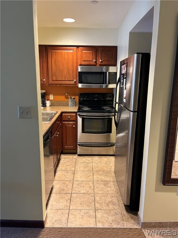 kitchen with light tile floors, appliances with stainless steel finishes, and sink