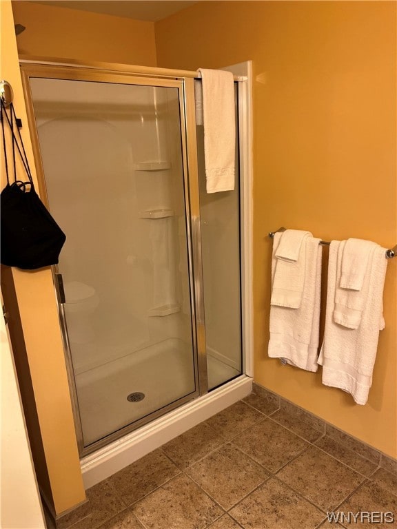 bathroom featuring tile floors and a shower with shower door