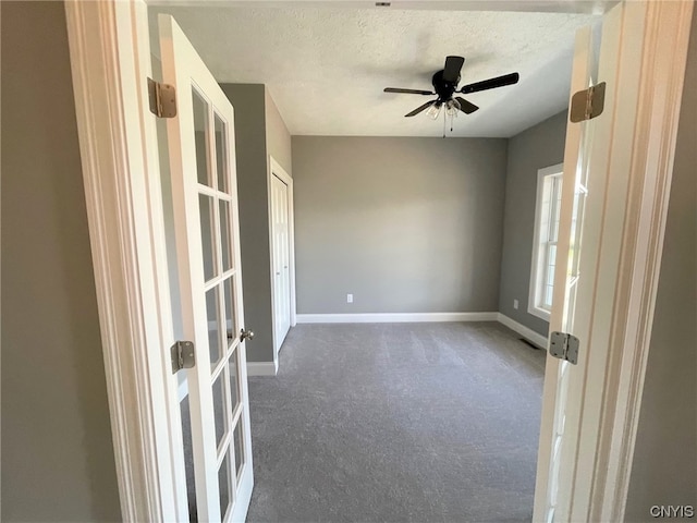 carpeted empty room featuring ceiling fan and a textured ceiling