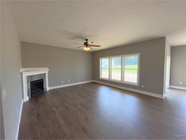 unfurnished living room with ceiling fan, a textured ceiling, and dark hardwood / wood-style floors