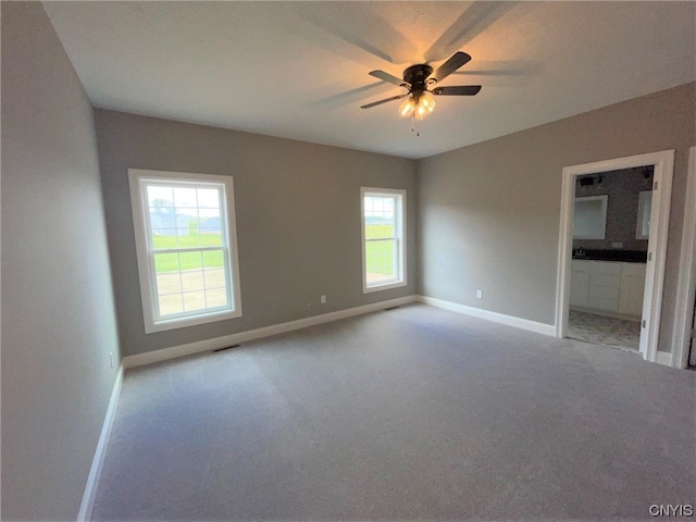 carpeted spare room featuring ceiling fan