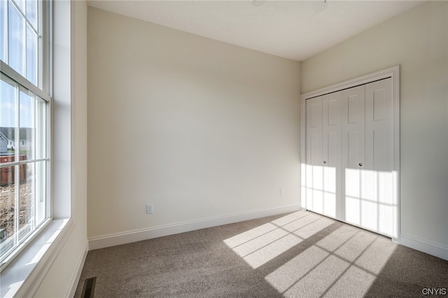 unfurnished bedroom featuring light colored carpet and a closet