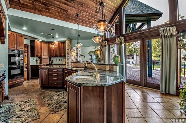 1567 Lake Rd, Porter, NY 14174 - kitchen with tile flooring, a kitchen island with sink, double oven, and pendant lighting