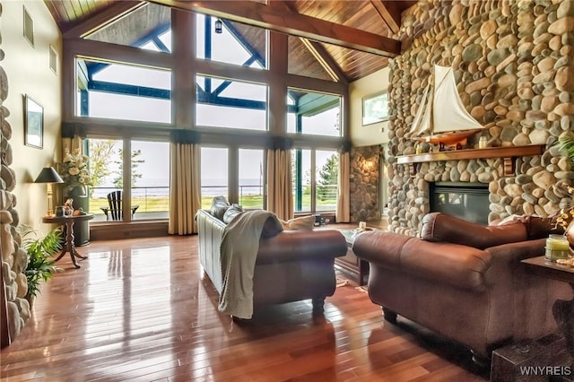 1567 Lake Rd, Porter, NY 14174 - living room featuring a fireplace, hardwood / wood-style floors, plenty of natural light, high vaulted ceiling, and a wooden ceiling with exposed beams