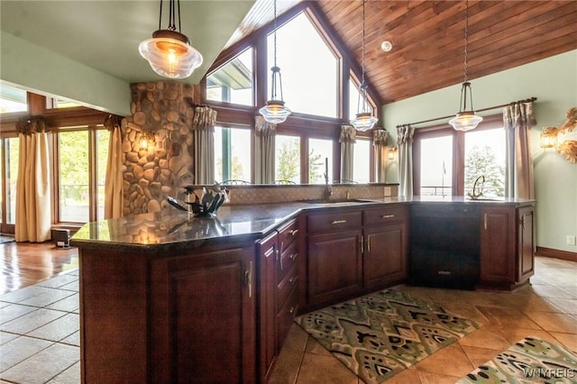 1567 Lake Rd, Porter, NY 14174 - kitchen with dark countertops, healthy amount of natural light, pendant lighting, light tile patterned floors, and high vaulted ceiling