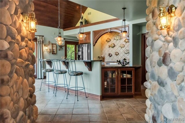 1567 Lake Rd, Porter, NY 14174 - bar area featuring stainless steel fridge, dark tile patterned flooring, lofted ceiling, wood ceiling, and hanging light fixtures