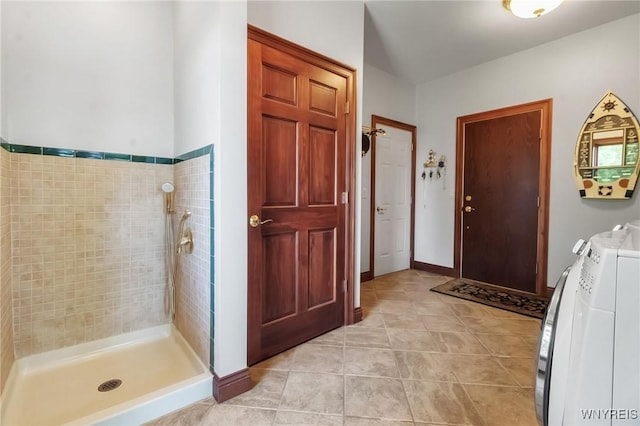 1567 Lake Rd, Porter, NY 14174 - bathroom with tile patterned flooring, washing machine and clothes dryer, and tiled shower