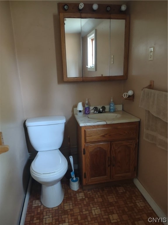 bathroom with tile flooring, toilet, and vanity