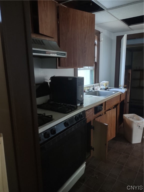 kitchen with white gas range oven, sink, premium range hood, and dark tile floors