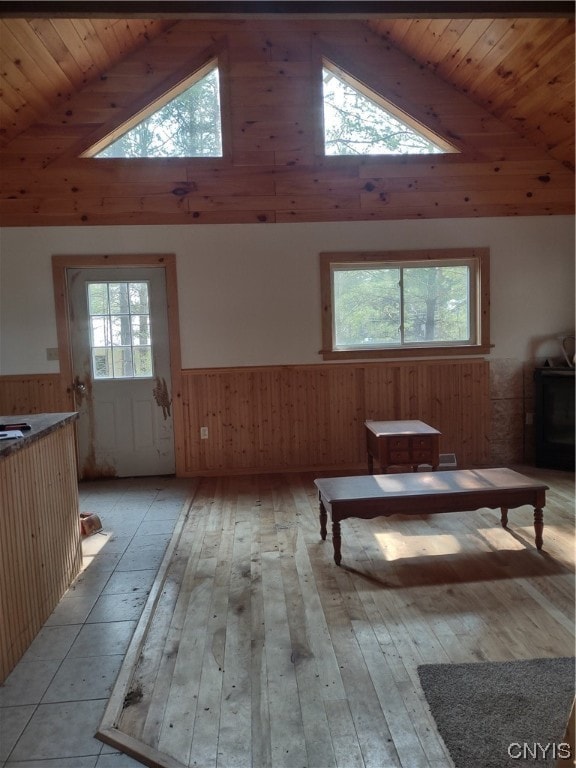 living room featuring high vaulted ceiling, light hardwood / wood-style floors, and wooden ceiling