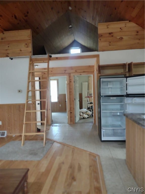 kitchen featuring stainless steel fridge, wood ceiling, light tile floors, and lofted ceiling