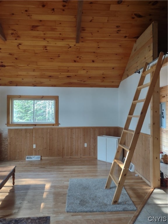 unfurnished room with lofted ceiling, wood walls, wooden ceiling, and light hardwood / wood-style floors