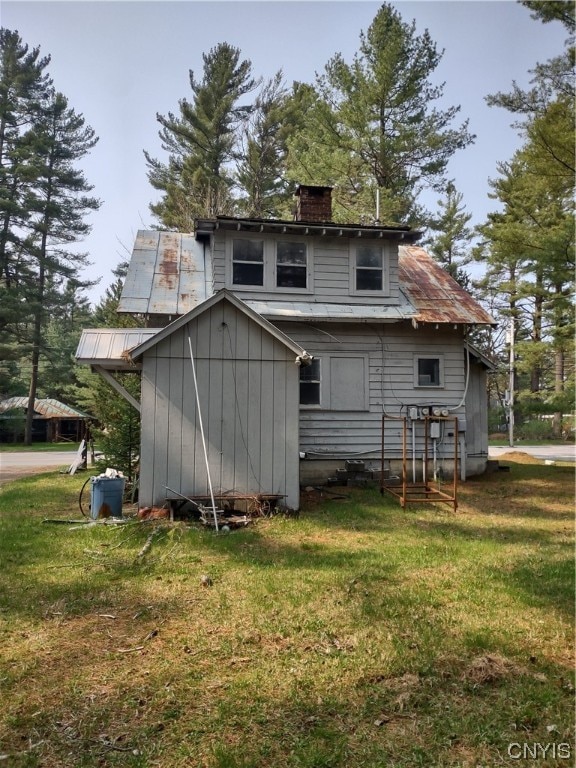 rear view of property featuring a lawn